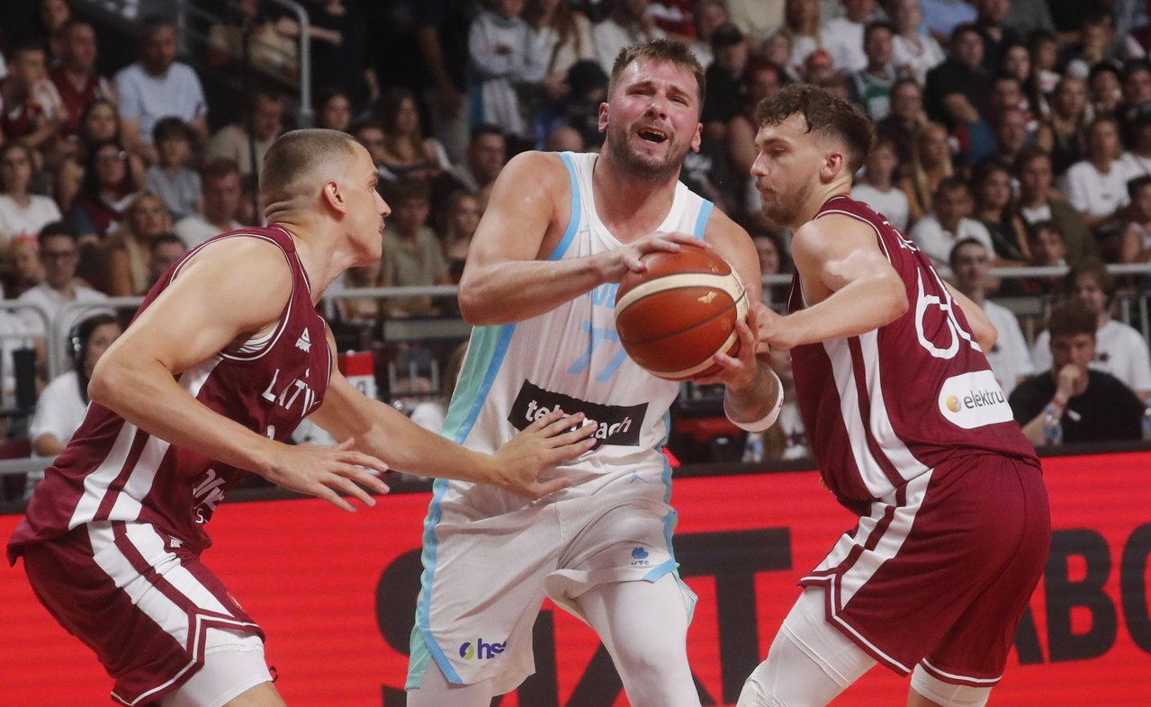 epa12304796 Andrejs Grazulis (L) and Kristers Zoriks (R) of Latvia and Luka Doncic of Slovenia in action during the friendly basketball match between Latvia and Slovenia in Riga, Latvia, 16 August 2025.  EPA/TOMS KALNINS 欧洲新闻图片社